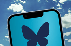 Close-up of a smartphone with a butterfly logo on a blue screen, set against a bright, partly cloudy sky. The scene conveys a fresh, hopeful mood.